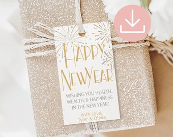 Peut inclure: Une étiquette cadeau rectangulaire blanche avec des illustrations de feux d'artifice dorés et argentés. Le texte indique Happy New Year, Wishing you health, wealth, & happiness in the new year! With Love, Tyler & Olivia. Attachée par une ficelle.