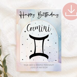 May include: A rectangular birthday card featuring a pastel watercolor background with a central arch containing the black text Gemini and a black zodiac symbol. The card includes the text Happy Birthday and Your lively & versatile personality lights up any room.