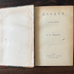 May include: A vintage book titled "Essays, Second Series" by R.W. Emerson. The book is published by James B. Lyon in Albany, New York.