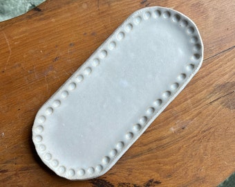 Bandeja de cerámica con bordes de puntos en forma de píldora