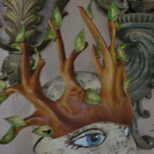 May include: A brown leather mask with a tree branch design and green leaves. The mask has a face with a painted eye and a textured background.