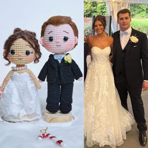 Peut inclure: Deux poupées au crochet représentant une mariée et un marié, placées à côté d'une photographie d'un couple en tenue de mariage. La poupée mariée porte une robe blanche et un collier de perles, tandis que le marié porte un costume noir et un nœud papillon bleu clair.