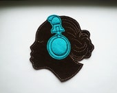 Brown skinned woman with headphones machine embroidered iron on sew on felt patch appliques in brown felt with cream and brown thread