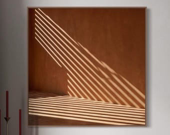 May include: A wall-mounted wooden sideboard with vertical slats, featuring a square framed print of light and shadow patterns, a brass floor lamp, a three-pronged candle holder with red candles, a small Buddha figurine, and a digital clock.