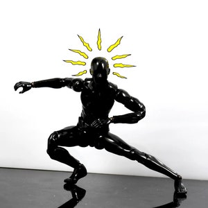 May include: A black action figure in a fighting pose with a yellow sunburst above its head.