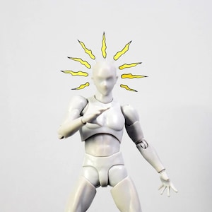 May include: A white plastic articulated figure with a yellow sunburst drawn above its head. The figure is posed with its arms outstretched and its hands open.