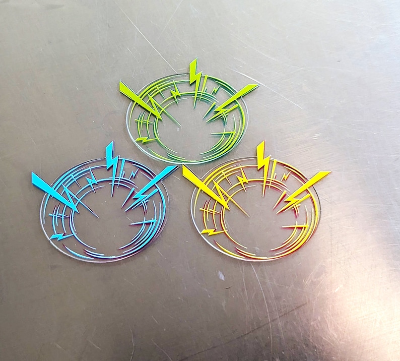 May include: Three circular stickers with a lightning bolt design. The stickers are transparent with yellow, blue, and red lightning bolts.