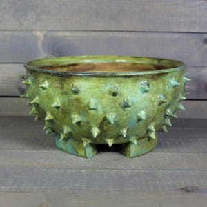 May include: A rustic wooden sign with the text "Welcome to our home" in white lettering. The sign features a distressed finish and a simple, inviting design, perfect for entryway decor.