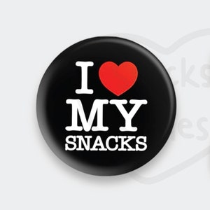 May include: Three round buttons with the text "I love my snacks" and a red heart. The buttons are black, white, and black with a red heart.