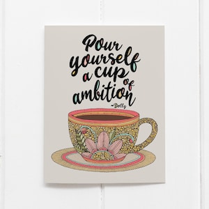 May include: A rectangular print on a light gray background featuring a coffee cup and saucer with intricate floral and geometric patterns in shades of pink, yellow, and green. The text reads, "Pour yourself a cup of ambition ~Dolly".