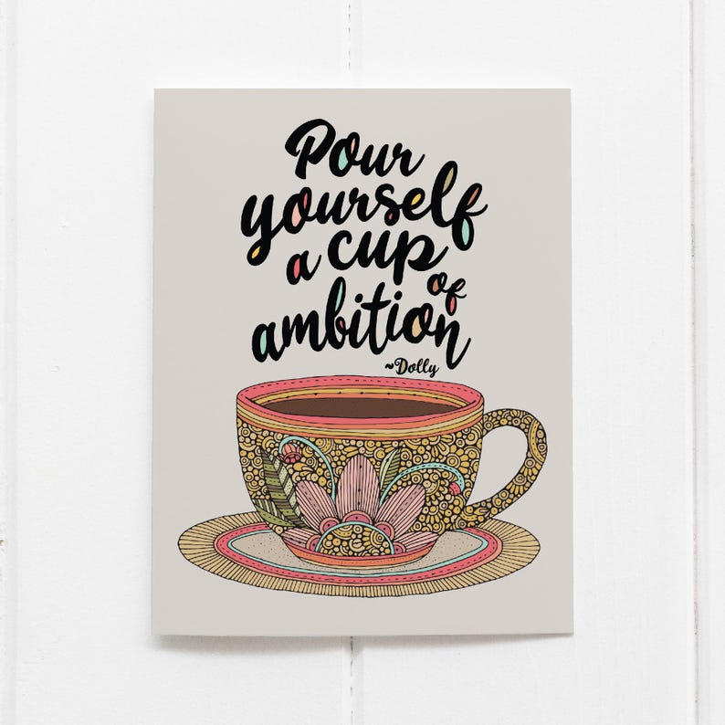 May include: A rectangular print on a light gray background featuring a coffee cup and saucer with intricate floral and geometric patterns in shades of pink, yellow, and green. The text reads, "Pour yourself a cup of ambition ~Dolly".
