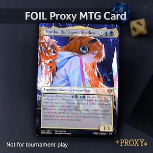 Puede incluir: Una carta MTG proxy foil con una ilustración de estilo anime de Yuriko, la Sombra del Tigre. La carta tiene un esquema de color azul y dorado con el texto "Commander ninjutsu". La carta está marcada "1/3" y "Not for tournament play".