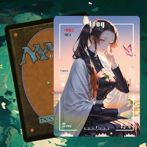 Puede incluir: Una carta de Magic: The Gathering con una ilustración de estilo anime de una mujer con cabello negro y un accesorio para el cabello de mariposa. La carta tiene la palabra "Frog" y "REC". El fondo es una escena de puesta de sol con mariposas.