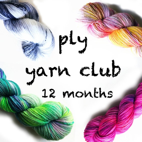 Black crayon writing says "ply yarn club 12 months" in the white center with yarn bundles in each corner in shades of blue, orange and yellow, green, and red and pink.