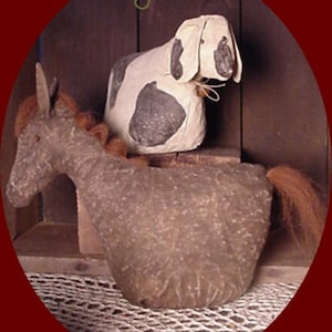 Op de afbeelding: Een rustiek, handgemaakt paard en koe duo gemaakt van getextureerd papier. Het paard is grijs met een bruine manen en staart, terwijl de koe wit is met zwarte vlekken. De tekst "Sawdust Barnyard Duo" en "Horse & Moocow" is zichtbaar.