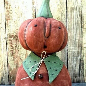 以下が含まれることがあります： 緑色の茎、茶色の目、緑と白のドット柄の襟が付いた、手作りのパンプキンジャックの胸像。胸像は布製で、素朴なビンテージ風です。