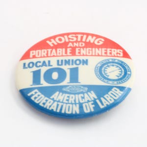 May include: A round button with a red, white, and blue design. The button features the text "HOISTING AND PORTABLE ENGINEERS LOCAL UNION 101" and "AMERICAN FEDERATION OF LABOR". A vintage collectible.