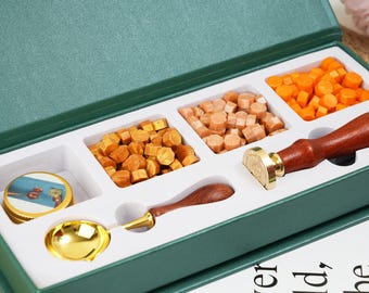 May include: A green box with a set of wax seal supplies. The box contains a gold spoon, a wooden handle wax seal stamp, and three compartments filled with different colored wax beads.