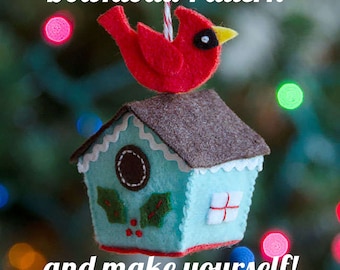 May include: A felt birdhouse ornament with a red cardinal perched on top. The birdhouse is blue with a brown roof and white trim. The ornament is hanging from a string. The text "Download Pattern and make yourself!" is at the bottom of the image.
