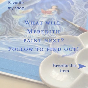 May include: A watercolor painting of a woman in a blue dress with a book in her hand. The painting is on a white surface with a white paint palette and a paintbrush. The text "WHAT WILL MEREDITH PAINT NEXT? FOLLOW TO FIND OUT!" is written on the surface.