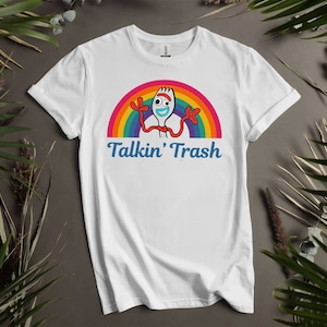 May include: White t-shirt featuring a rainbow and a cartoon character holding a fork. The text "Talkin' Trash" is printed below the image.
