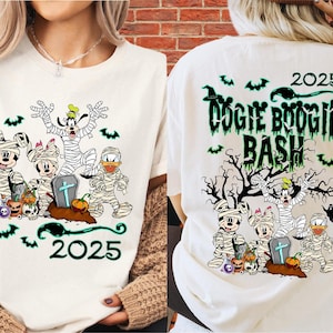 Könnte beinhalten: Weißes T-Shirt mit einem Halloween-Design. Auf der Vorderseite sind Zeichentrickfiguren, darunter Mickey und Minnie Mouse, als Mumien verkleidet, mit dem Jahr "2025". Auf der Rückseite steht "Oogie Boogie Bash" mit Fledermäusen und einem gruseligen Baum.
