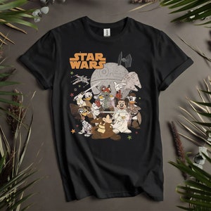 以下が含まれることがあります： スターウォーズのキャラクターに扮したミッキーマウスとその仲間たちのグラフィックがプリントされた黒いTシャツ。グラフィックの上に「STAR WARS」の文字がプリントされています。