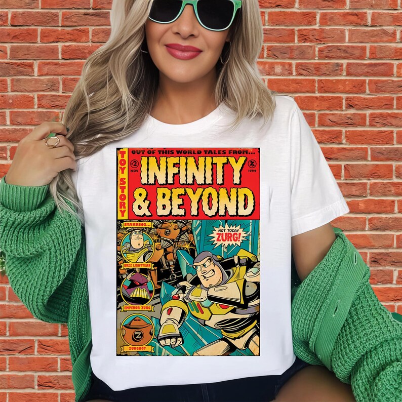 Puede incluir: Camiseta blanca con un dise&ntilde;o de c&oacute;mic que muestra el texto "INFINITY & BEYOND" y "TOY STORY". El dise&ntilde;o incluye ilustraciones de Buzz Lightyear y otros personajes. La camiseta tiene cuello redondo.