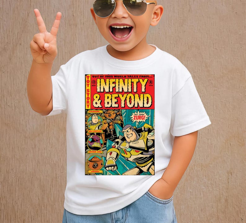 Puede incluir: Camiseta blanca con un dise&ntilde;o de portada de c&oacute;mic con el texto "INFINITY & BEYOND" e im&aacute;genes de personajes de la pel&iacute;cula Toy Story. La camiseta la lleva un ni&ntilde;o con gafas de sol.