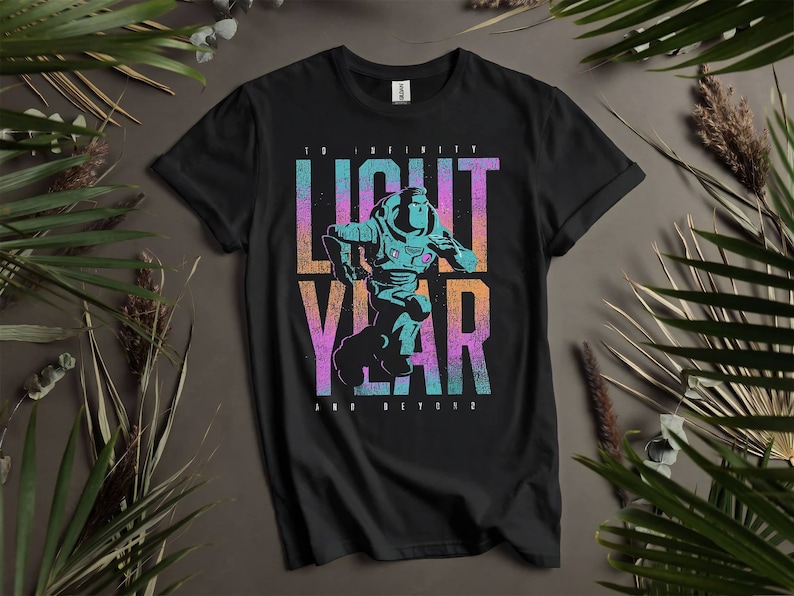May include: Black t-shirt with a graphic print of a cartoon space ranger running. The text "To Infinity and Beyond" is printed below the graphic. The graphic is in shades of blue, pink, and green.