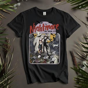 Puede incluir: Camiseta negra con un diseño gráfico rectangular con personajes de "Pesadilla antes de Navidad". El diseño incluye a Jack Skellington, Sally y Oogie Boogie. Las palabras "Nightmare on Main St" están arriba.