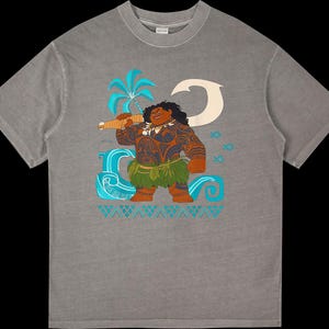 Puede incluir: Camiseta gris con una ilustraci&oacute;n de dibujos animados de un personaje polinesio. El dise&ntilde;o incluye una palmera, olas y peces en tonos azules y blancos. El personaje tiene tatuajes, una falda de hierba y un arma.