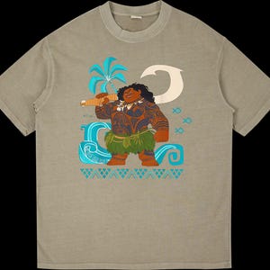 Puede incluir: Camiseta color beige con un gr&aacute;fico colorido de un personaje polinesio sosteniendo un arma. El dise&ntilde;o incluye una palmera, olas del oc&eacute;ano y s&iacute;mbolos de peces. El personaje est&aacute; representado con tatuajes y una falda de hierba.