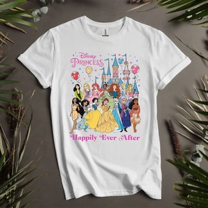 May include: White t-shirt featuring a colorful graphic of Disney Princesses with a castle, balloons, and the text "Disney Princess Happily Ever After" in pink. The design includes various princesses in their iconic outfits.