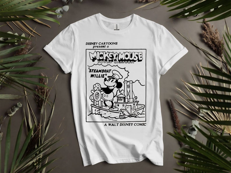 May include: White t-shirt with a black and white illustration of Mickey Mouse as a steamboat captain. The text reads "DISNEY CARTOONS present a MICKEY MOUSE SOUND CARTOON 'STEAMBOAT WILLIE' A WALT DISNEY COMIC".