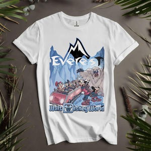 Puede incluir: Camiseta blanca con un gr&aacute;fico colorido de una monta&ntilde;a rusa con Mickey Mouse y sus amigos. El dise&ntilde;o incluye la palabra "Everest" y "Walt Disney World" en una escena de monta&ntilde;a azul y negra.