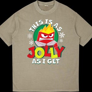 Puede incluir: Camiseta color beige con un personaje de dibujos animados enfadado con llamas amarillas en la cabeza. El texto dice "THIS IS AS JOLLY AS I GET" en rojo, amarillo y blanco.