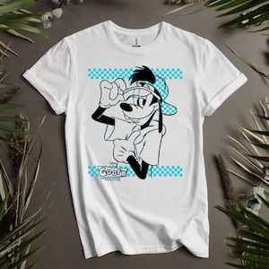 May include: White t-shirt featuring a black and white cartoon illustration of Goofy from "A Goofy Movie." Goofy is wearing a hat and holding his glasses. The shirt has a blue checkered pattern and the movie title.