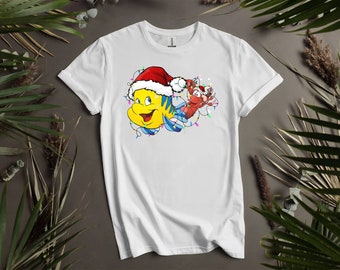 Camisetas personalizadas con luces navideñas de Santa Flounder y Sebastian para hombres, mujeres y niños. Tallas S a 5XL. Camisetas para mujer disponibles. K90