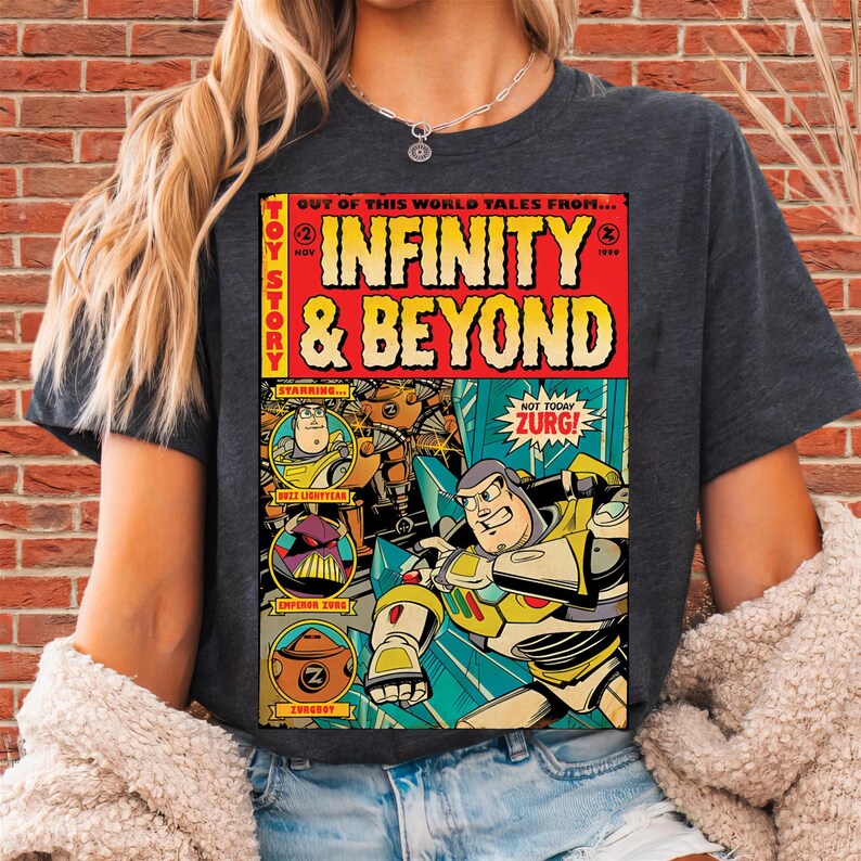 Puede incluir: Camiseta gris oscuro con un dise&ntilde;o gr&aacute;fico estilo c&oacute;mic que presenta el texto "INFINITY & BEYOND" y personajes de Toy Story. El dise&ntilde;o incluye a Buzz Lightyear y al Emperador Zurg. La camiseta tiene mangas cortas.
