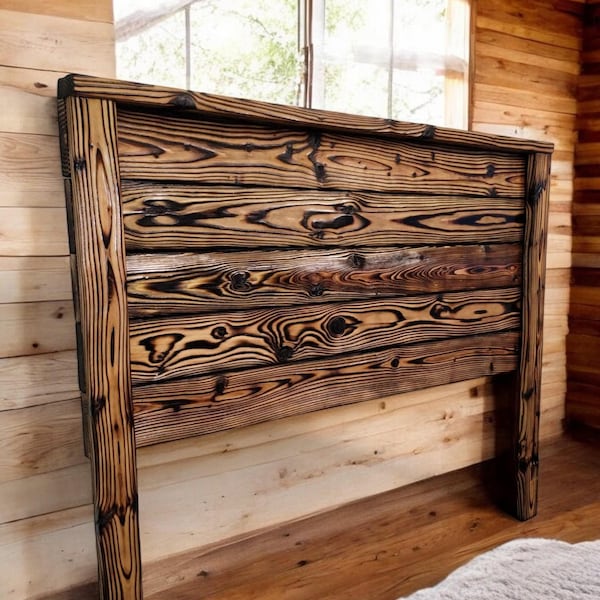 May include: A rustic wooden headboard with a dark brown finish and a natural wood grain pattern. The headboard is made of reclaimed wood and has a distressed look.