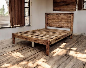 Puede incluir: Un marco de cama de madera rústico con una cabecera y un piecero de listones. El marco de cama está hecho de madera recuperada y tiene un acabado natural y desgastado.