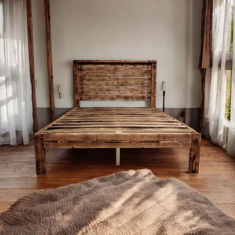 Puede incluir: Un marco de cama de madera r&uacute;stica con una cabecera y un piecero de listones. El marco de cama est&aacute; hecho de madera recuperada y tiene un acabado natural y desgastado.