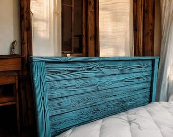 Puede incluir: Una cabecera de cama de madera azul turquesa con un aspecto rústico y de madera recuperada. La cabecera está hecha de tablones de madera con un acabado desgastado. La cabecera está sobre un colchón blanco con la palabra "BAMBOO" impresa en él.