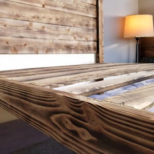 Puede incluir: Un marco de cama de madera r&uacute;stico con una cabecera de listones y una base de listones. La madera tiene un acabado natural y desgastado.