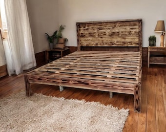 Puede incluir: Un marco de cama de madera rústico con una cabecera y un piecero de listones. El marco de la cama está hecho de madera recuperada y tiene un acabado natural y desgastado.