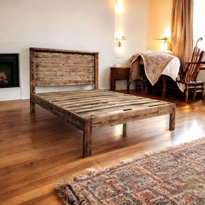 Puede incluir: Un marco de cama de madera r&uacute;stico con una cabecera y un piecero de listones. El marco de cama est&aacute; hecho de madera recuperada y tiene un acabado natural y desgastado.