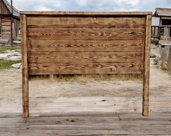 Puede incluir: Una cabecera de cama de madera rústica con un acabado marrón natural. La cabecera está hecha de tablones de madera horizontales y tiene un diseño simple y rectangular.