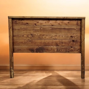 May include: A rustic wooden headboard with a natural brown finish. The headboard is made of reclaimed wood planks and has a simple, farmhouse style.