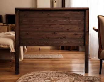 Puede incluir: Una cabecera de cama de madera marrón oscuro con listones horizontales. La cabecera está sobre un suelo de madera con una alfombra delante.